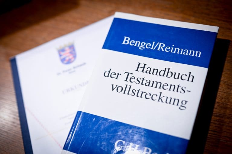Das Handbuch der Testamentsvollstreckung mit einer Urkunde auf einem Tisch