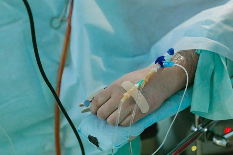 Eine Person im Krankenhausbett mit einem Zugang