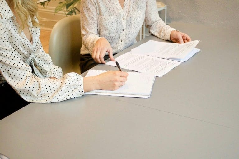 zwei Frauen, die Dokumente unterzeichnen