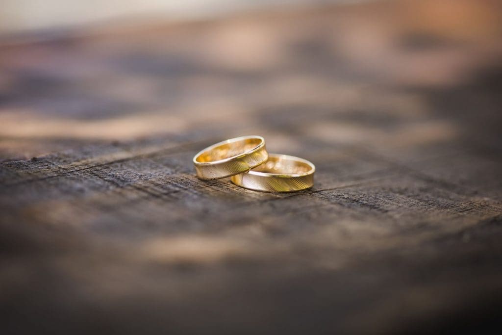 Nahaufnahme zweier goldener Ringe auf einem Holzuntergrund