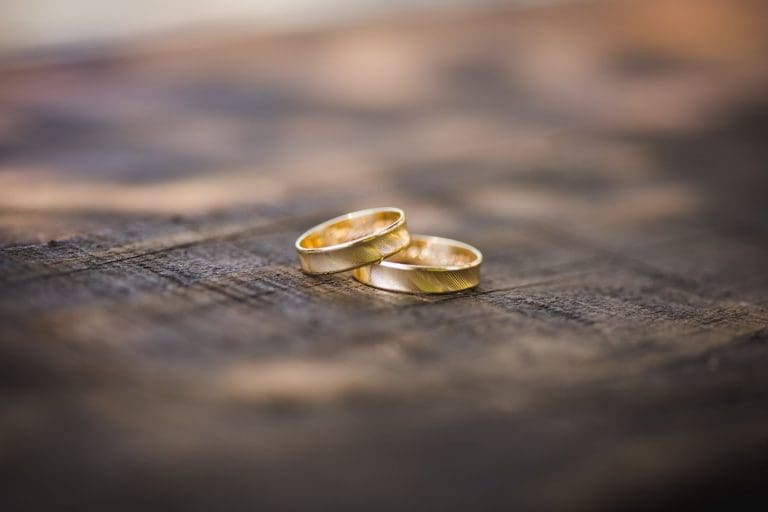 Nahaufnahme zweier goldener Ringe auf einem Holzuntergrund