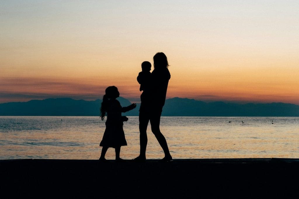 Frau und zwei Kinder am Strand